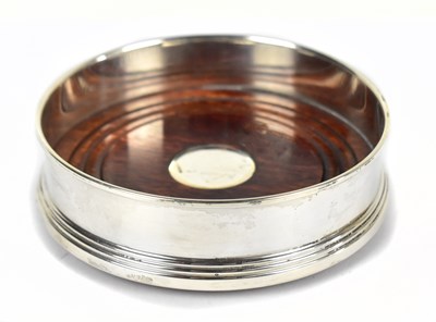 Lot 1185 - W.I BROADWAY & CO; an Elizabeth II hallmarked silver mounted bottle coaster