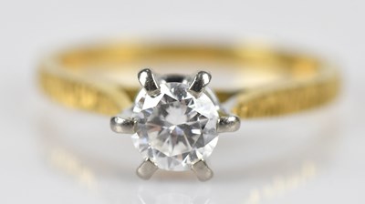 Lot 393 - A diamond solitaire dress ring in a yellow...