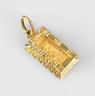 Lot 29 - A yellow metal charm of classical ruins,...