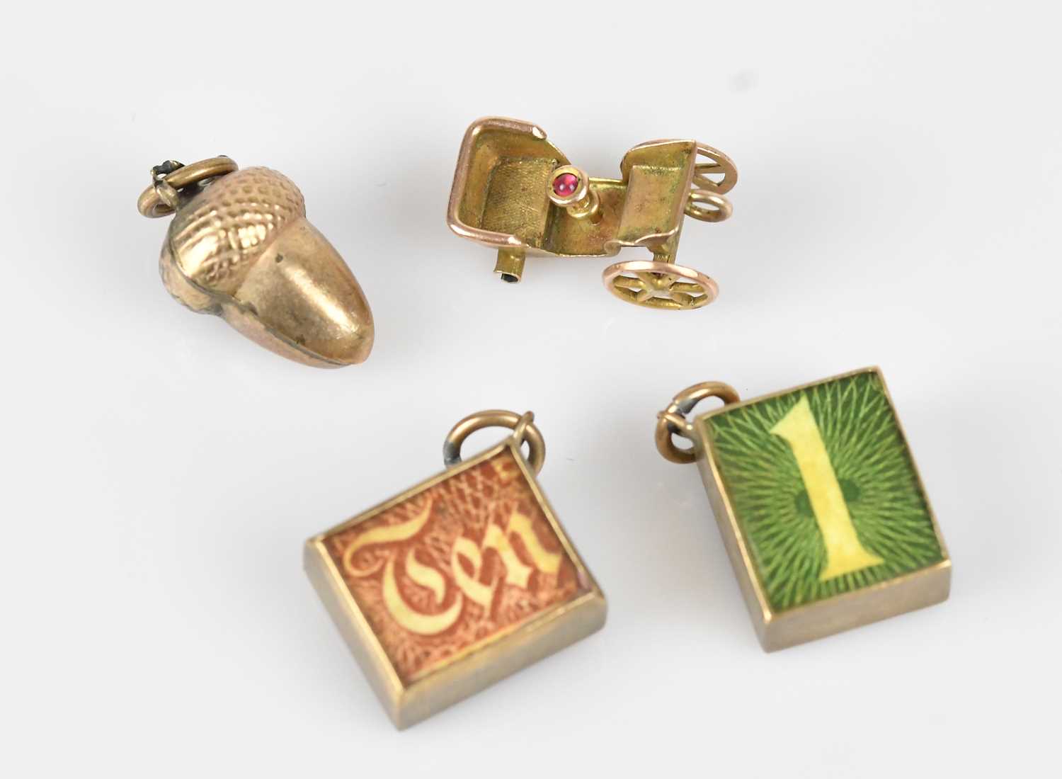 Lot 18 - Three 9ct gold novelty charms, including a £10...