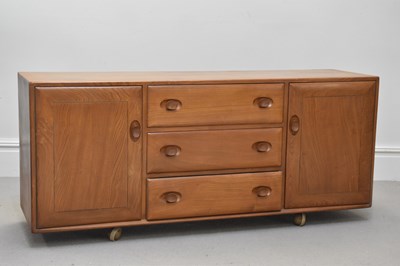 Lot 2114 - ERCOL; a light oak sideboard, with three...