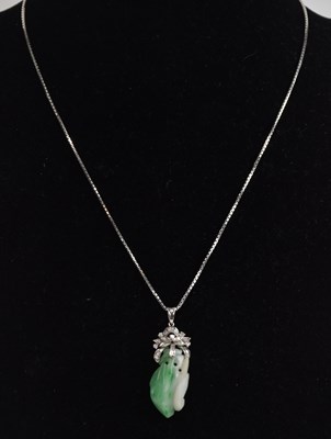 Lot 1373 - An 18K white gold diamond set carved green...