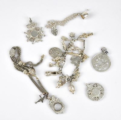 Lot 619 - A white metal charm bracelet stamped 'Silver',...