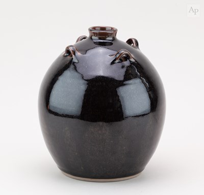 Lot 629 - A bulbous lugged stoneware bottle covered in...