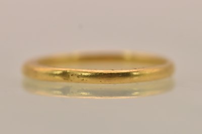 Lot 1336 - A 22ct yellow gold thin band ring in the shape...
