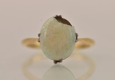 Lot 1340 - An 18ct gold opal set ring, the oval white and...