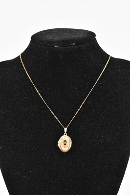 Lot 258 - A 9ct yellow gold locket of oval form, set...