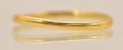 Lot 1350 - A misshapen yellow metal band ring, testing as...