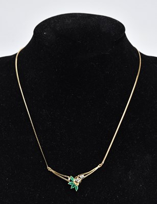 Lot 257 - A 9ct yellow gold diamond and emerald necklet...