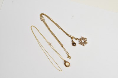 Lot 314 - Three 9ct gold pendants on fine link chains,...