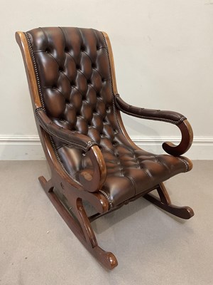 Lot 1122 - A reproduction button leather rocking chair.