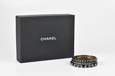 Lot 1433 - CHANEL; a large black resin CC bracelet inset...