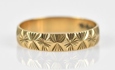 Lot 587 - A 9ct yellow part textured gold band, size K,...