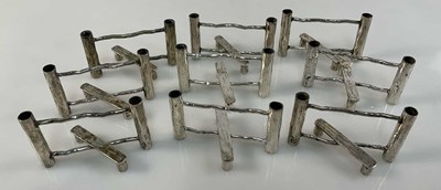 Lot 737 - A collection of nine silver plated knife rests...