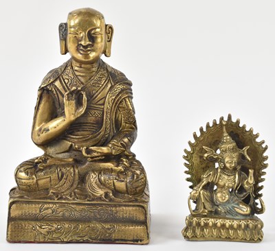 Lot 1021 - A Chinese brass figure of seated Buddha in...