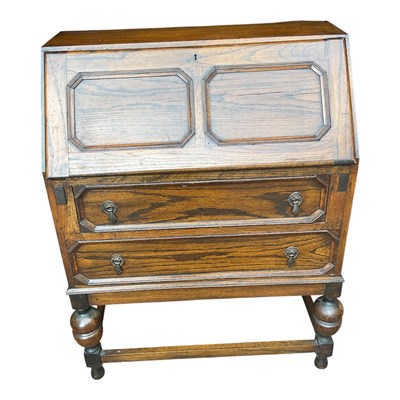 Lot 71 - A 1930s oak bureau with fall front enclosing a...