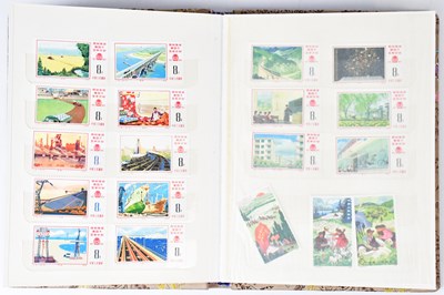 Lot 242 - A silk-covered stamp album containing a...