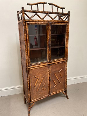 Lot 83 - A bamboo bookcase with two glazed doors above...
