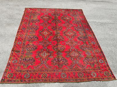 Lot 296 - A red ground Eastern hand knotted carpet, with...