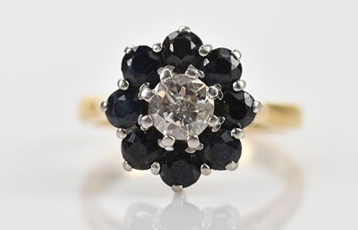 Lot 397 - A diamond and saphire daisy cluster ring, the...