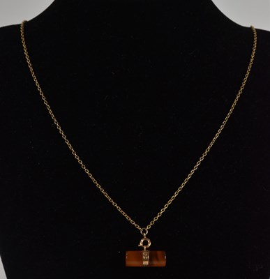 Lot 1333 - A 15ct yellow gold mounted amber rod pendant,...