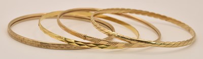 Lot 1405 - Four 9ct yellow gold bangles, all of different...
