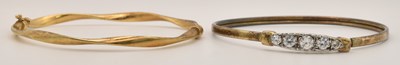 Lot 1424 - A gold plated bangle, set with five graduated...