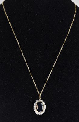 Lot 1329 - A 9ct yellow gold oval pendant, with central...