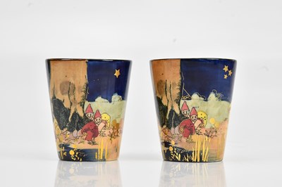 Lot 1353 - ROYAL DOULTON; a pair of beakers decorated...