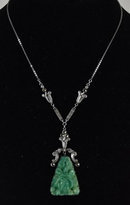 Lot 1469 - A Chinese carved green jade type pendant with...