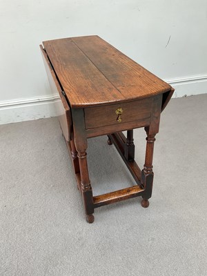 Lot 62 - An 18th century oak drop-leaf dining table...