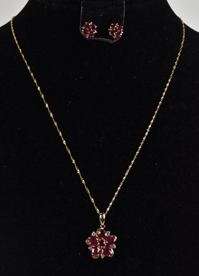 Lot 1337 - A 14ct yellow gold floral ruby and white topaz...