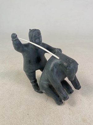 Lot 140 - An Inuit stone carving of a figure hunting a...