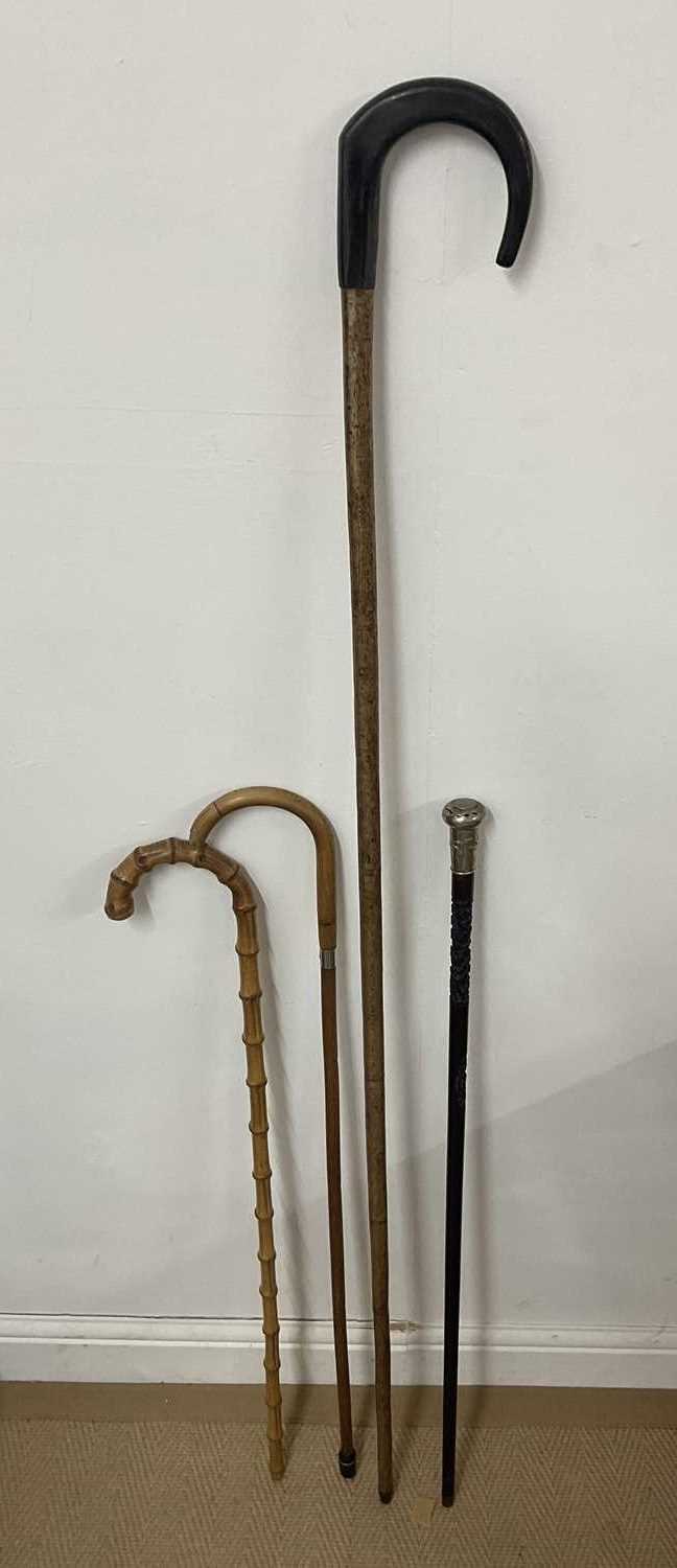 Lot 15 - Two bamboo style walking sticks, one with...