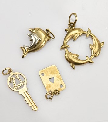 Lot 23 - A collection of four yellow metal charms,...