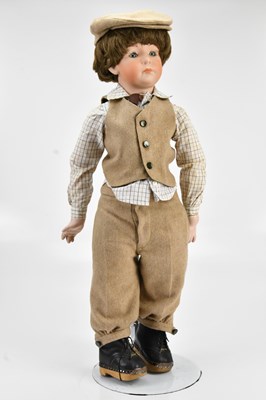Lot 2068 - A bisque headed doll of boy in tweed clothes,...
