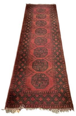 Lot 136 - A hand woven red ground woollen runner, with...