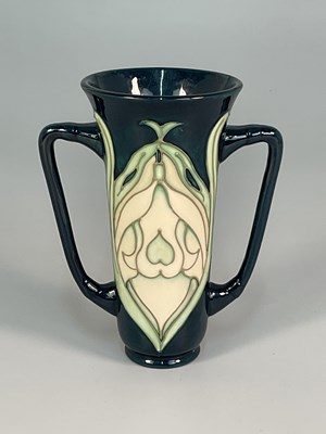 Lot 309 - MOORCROFT; a 'Snowdrop' pattern twin handled...
