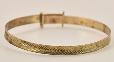 Lot 1440 - A yellow metal child's squeeze bangle,...