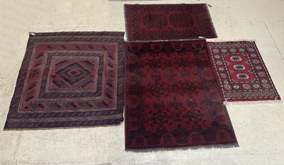 Lot 293 - An Afghan red ground rug with stylised...