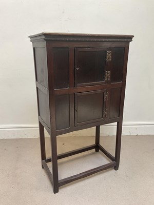 Lot 1077 - A 1920s oak cupboard on stand, with two...