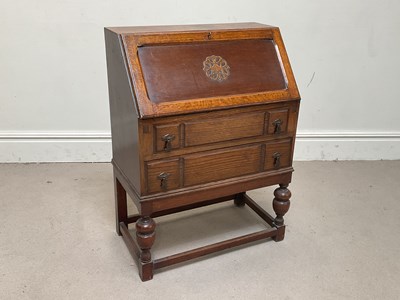 Lot 1085 - A 1930s oak bureau, with three drawers, on...