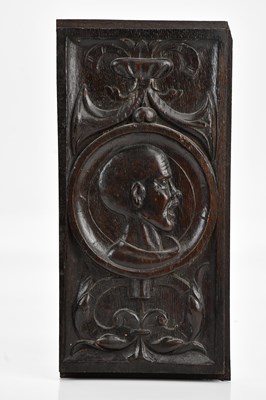 Lot 438 - A carved oak panel with a portrait of a bald...