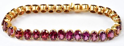 Lot 597 - An articulated yellow metal bracelet set with...