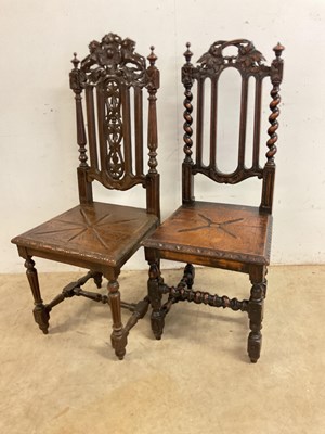 Lot 817 - Two carved oak hall chairs.