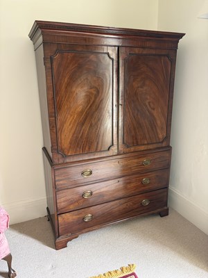 Lot 1166 - A George III mahogany linen press, with...