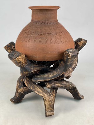 Lot 3 - An African terracotta pot on a hand carved...