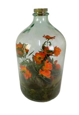 Lot 335 - A large glass carboy, with faux flowers within,...