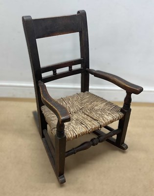 Lot 703 - A Victorian child's oak and rush rocking seat,...