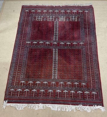 Lot 753 - A hand knotted Afghan Baluch rug, in deep red...